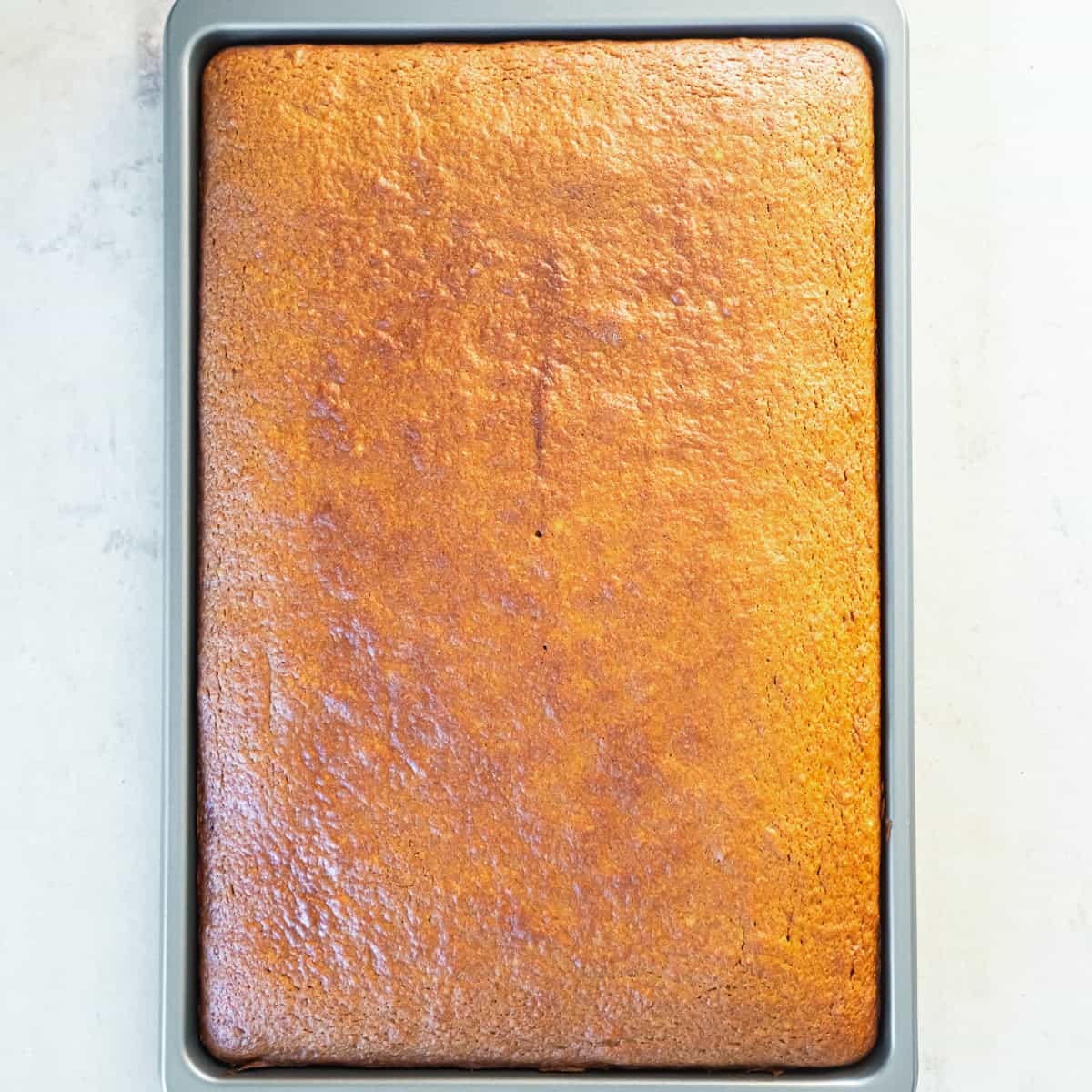 Baked pumpkin bars cooling in the rimmed baking pan before frosting.