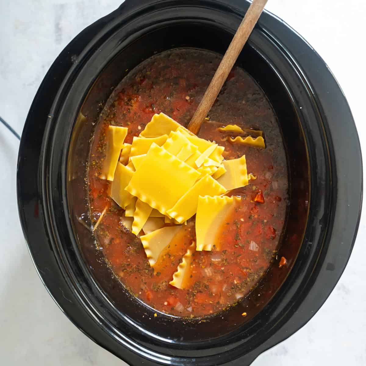 Broken curly lasagna noodles added to slow cooker lasagna soup.