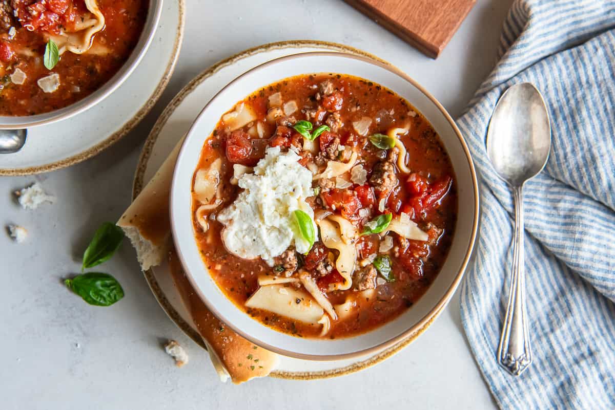 A bowl of slow cooker lasagna soup topped with a dollop of ricotta.